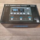 Krabice s produktem Boss GT-1000CORE Guitar Effects Processor. Na horní straně je zobrazen obrázek přístroje s nápisy BOSS GT-1000CORE, A-I-R-D a TON…