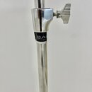 Detail chromovaného kovového stojanu s utahovacím šroubem a křídlovým knoflíkem. Na černém pásku je bílý nápis BAS Hardware. Povrch vykazuje drobné z…
