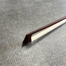 Detailní pohled na hrot smyčce s bílým vlasem. Hůl je vyrobena z tmavě hnědého dřeva s hladkým povrchem. Na fotografii nejsou žádné viditelné značky…