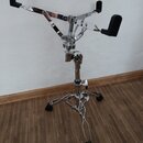 Chromovaný kovový stojan na hudební nástroj s černými gumovými oporami. Stojan má trojnožku a teleskopický středový sloupek s utahovacími šrouby. Pov…