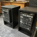 Dva černé studiové monitory v dřevěných krytech. Na zadním panelu obou zařízení je bílý nápis TRUTH B2031A a pod ním text HIGH-RESOLUTION REFERENCE S…