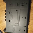 Zadní strana černého kytarového komba z plastu. Na středovém štítku je uveden název Blackstar AMPLIFICATION SUPER FLY a text C.E. ELECTRIC - ALKALI B…