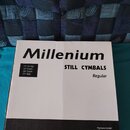 Bílá kartonová krabice s černým nápisem Millenium. Na krabici je text STILL CYMBALS Regular a seznam obsahu: 14" Hi-Hat, 16" Crash, 18" Crash, 20" Ri…