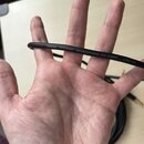 Černý audio kabel s bílým nápisem CORDIAL GERMANY MICROPHONE 2X0.22MM² CMN 220. Kabel je položen napříč dlaní ruky. Povrch kabelu vypadá hladce a bez…