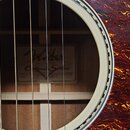 Detail znamení v otvoru akustické kytary. Uvnitř je vidět štítek s nápisy Fender ACCOUSTIC California Series a sériovým číslem CSB13 00917. Kytara má…