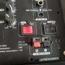 Detailní pohled na ovládací panel černého elektronického zařízení. Jsou zde vidět tři otočné potenciometry s nápisy MIC VOL, ECHO a MAX/MIN, dva červ…