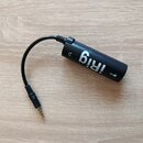 Černý cylindrický audio rozhraní s krátkým integrovaným kabelem zakončeným 3,5mm jack konektorem. Na těle je bílý nápis iRig a symbol v podobě šipky.…