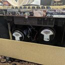 Zadní strana kytarového komba v béžovém potahu. Na horním ovládacím panelu jsou nápisy Classic 50/212, PEAVEY a MADE IN CHINA. V otevřeném zadním pro…