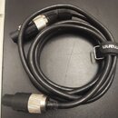 Černý audio kabel svázaný v kruh, zakončený dvěma konektory typu XLR. Na černém stahovacím pásku je bílý nápis mann. Povrch kabelu a konektorů vykazu…