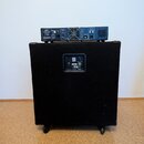 Černý basový reproduktor v kostce na kolečkách s nápisem EV Electro-Voice a označením CX1200. Na horní části reproduktoru je umístěn rackový zesilova…