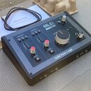 Černý audio rozhraní s nápisy SSL 2, USB AUDIO INTERFACE a 24-BIT / 192 kHz. Na horním panelu jsou ovládací prvky pro CHANNEL 1 a CHANNEL 2, dva červ…