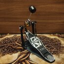 Černý basový pedál značky TAMA. Na stupni je bílý nápis TAMA a stylizované logo Iron Cobra s textem The Legend in Tradition. Pedál má kovovou konstru…