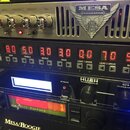 Detailní pohled na rackové zařízení s nápisy MESA ENGINEERING, PRE V-TWIN AMP a MESA/BOOGIE. Horní část obsahuje stříbrné ovládací knoflíky a nápisy…