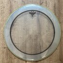 Průhledný plastový buben s černým kruhovým potiskem. V horní části je logo a nápisy REMO, WEATHERKING, POWERSSTROKE 3 BASS a MADE IN U.S.A. Povrch je…