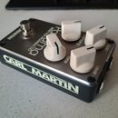 Kytarový efekt pedál v černém kovovém krytu s bílými ovládacími knoflíky. Na horní části je nápis Panorama British Hot Modded OD a popisky ovládací p…