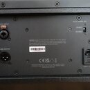 Záběr na zadní panel černého elektronického zařízení. Jsou zde vidět konektory LINE INPUT s nápisem PUSH, LINK OUTPUT a napájecí vstup. Na panelu je…
