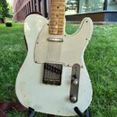Bílá elektrická kytara typu Telecaster s bílým pickguardem a hnedým javorovým hmatníkem. Povrch kytary vykazuje výrazné opotřebení v podobě zahlreich…