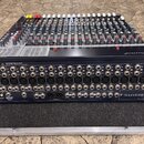 Míchací pult značky Soundcraft v černém provedení s velkým množstvím potenciometrů a posuvníků. Na zadním panelu jsou vidět početné konektory XLR, ja…