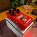 Červený efekt pedál s nápisem HALL OF FAME a tc electronic. Na horní straně jsou čtyři černé ovládací knoflíky, stříbrný spínač a nápisy STEREO IN MO…