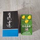Zelený efekt pedál s nápisem VINTAGE OVERDRIVE a logem Harley Benton. Pedál má tři žluté oválné ovládací knoflíky s popisky DRIVE, TONE a VOLUME, spí…