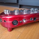 Červený kovový efekt pedál s chromovanými oválnými knoflíky. Na zadní straně jsou umístěny vypínač, konektory pro napájení, XLR vstup, USB port a Eth…