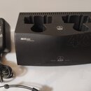 Černá nabíjecí stanice s nápisy CU400 CHARGING UNIT a 400 AUTO DEVICE SCAN. Na horní části i v dolní středové části je bílé logo AKG, vedle kterého j…