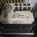 Kremově bílý kytarový zesilovač s černými ovládacími knoflíky a černou rukojetí. Na horní i přední straně je nápis „The Duchess Vt4 Guitar Amp“ a vle…