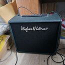 Kytarový kombo zesilovač s tmavě zeleným povrchem z textilu a černou přední síťovkou. Na síťovce je bílý nápis Hughes & Kettner. Horní panel obsahuje…