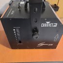 Černý generátor mlhy s rukojetí pro přenos. Na přístroji jsou bílé nápisy CHAUVET a HURRICANE HAZE 3D, dále označení MAXIMUM a MINIMUM u kontrolní st…