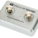 Stříbrný kovový pedál s dvěma stoupacími spínači. Na horní straně je černý nápis SINGULAR SOUND a pod spínači text FOOTSWITCH+. Povrch je matný, v do…