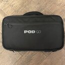 Černý textilní přepravní kufr s rukojetí a zipem. Uprostřed je bílý nápis POD GO. Povrch materiálu vypadá čistě a v dobrém stavu.