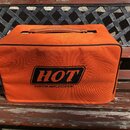 Oranžový textilní kryt na zesilovač s rukojetí nahoře a černým lemováním hran. Na přední straně je umístěno černé logo s nápisem HOT a pod ním text C…