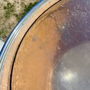Detailní pohled na horní hranu korpusu bubnu. Viditelný je kovový obruč a vnitřní dřevěný povrch s viditelnou strukturou vláken. Povrch vnitřku je zn…