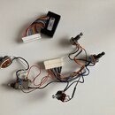 Sada elektroniky pro hudební nástroj obsahující čtyři potenciometry a černý plastový modul s bílým konektorem. Na modulu je bílá nálepka s nápisy „El…