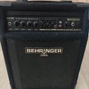 Černý basový kombo zesilovač značky BEHRINGER v textilním potahu. Na horním ovládacím panelu je nápis BXL450 45-WATT 2-CHANNEL BASS WORKSTATION a ovl…