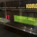 Detailní pohled na černý efektový procesor s nápisy DUAL DIGITAL EFFECT PROCESSOR DRV-3000 a žlutým logem KORG. Zařízení má digitální displej, na kte…