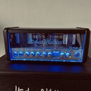 Kytarový zesilovač značky Hughes & Kettner, model TubeMeister 18. Přední panel je vybaven ovládacími knoflíky pro Treble, Mid, Bass, Master Gain a Cl…