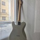 Zadní strana elektrické kytary v krémové barvě s jasným lakem. Na zadní straně korpusu je vidět logo Squier a nápis CE. Hmatník a hlava jsou vyrobeny…