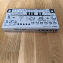 Stříbrný analogový sekvencér s nápisy Analog Bass Line Synthesizer, behringer a TD-3. Zařízení obsahuje zahlreiche ovládací knofíky, tlačítka a přepí…