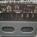 Zadní strana basového komba v černém texturovaném potahu. Na ovládacím panelu jsou nápisy INPUT POWER 230V~50Hz 80W, PARALLEL SPEAKER OUTPUTS 15 WATT…