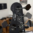 Záběr na zadní stranu hlavy černé basové kytary. Jsou vidět čtyři ladicí mechanismy s černými knoflíky. Na povrchu je bílý nápis YAMAHA, text MADE IN…