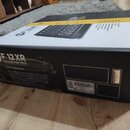 Kartonová krabice s míchací konzolí. Na boku je bílý nápis RCF F 12 XR PROFESSIONAL MIXING CONSOLE a text The F 12XR-Features. V pravém dolním rohu j…