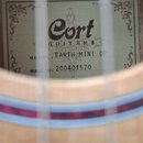 Detail vnitřku akustické kytary s viditelným štítkem. Na štítku je uveden nápis Cort GUITARS, MODEL: EARTH MINI OP a SERIAL NO: 200401570. V dolní čá…
