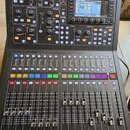 Černý digitální mixovací pult značky mdas. Horní část obsahuje displej, ovládací knoflíky a tlačítka v sekcích TALKBACK, MONITOR, REC, COMP/PREAMP, E…