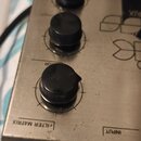 Kovový efekt pedál stříbrné barvy se třemi černými otočnými knoflíky. Na horní straně je vidět část loga a nápisy „COR“, „FILTER MATRIX“ a „INPUT“. P…