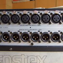 Detailní pohled na zadní panel audio zařízení s řadou konektorů. Horní řada obsahuje osm vstupů XLR s nápisem ANALOG INPUT BALANCED (+4dBu) a spodní…