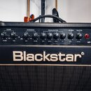 Detailní pohled na ovládací panel kytarového komba černé barvy. Na panelu jsou nápisy CLEAN, OVERDRIVE, EQUALISATION, REVERB a MASTER s řadou ovládac…