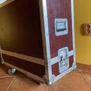 Kubeček z tmavě červeného materiálu s hliníkovými hranami a rohy. Na pravém boku jsou umístěny dvě kovové madla s zámky. Povrch vykazuje známky opotř…