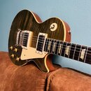Elektrická kytara typu Les Paul s žlutým průsvitným lakem a výraznou sletovanou strukturou dřeva. Nástroj má dva humbuckery s krémovými kryty, čtyři…