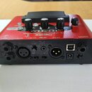 Červený procesor vokálních efektů značky BOSS, model VE-2 Vocal Harmonist. Na zadní straně jsou viditelné konektory s nápisy MIC IN, MIC SENS., PHONE…